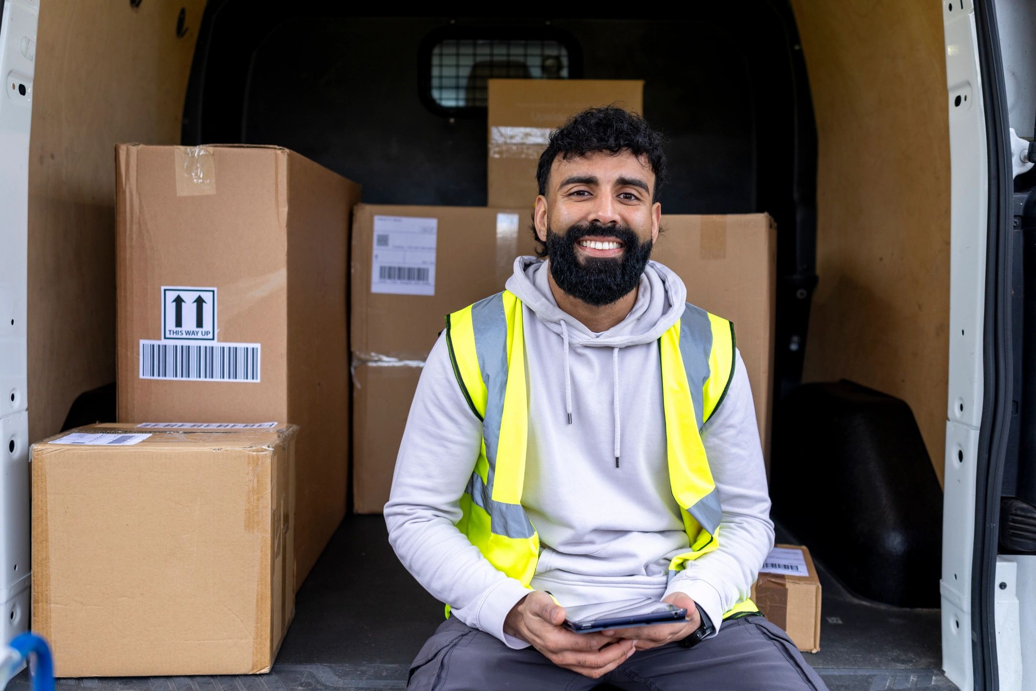 Delivery driver organizing packages from a van