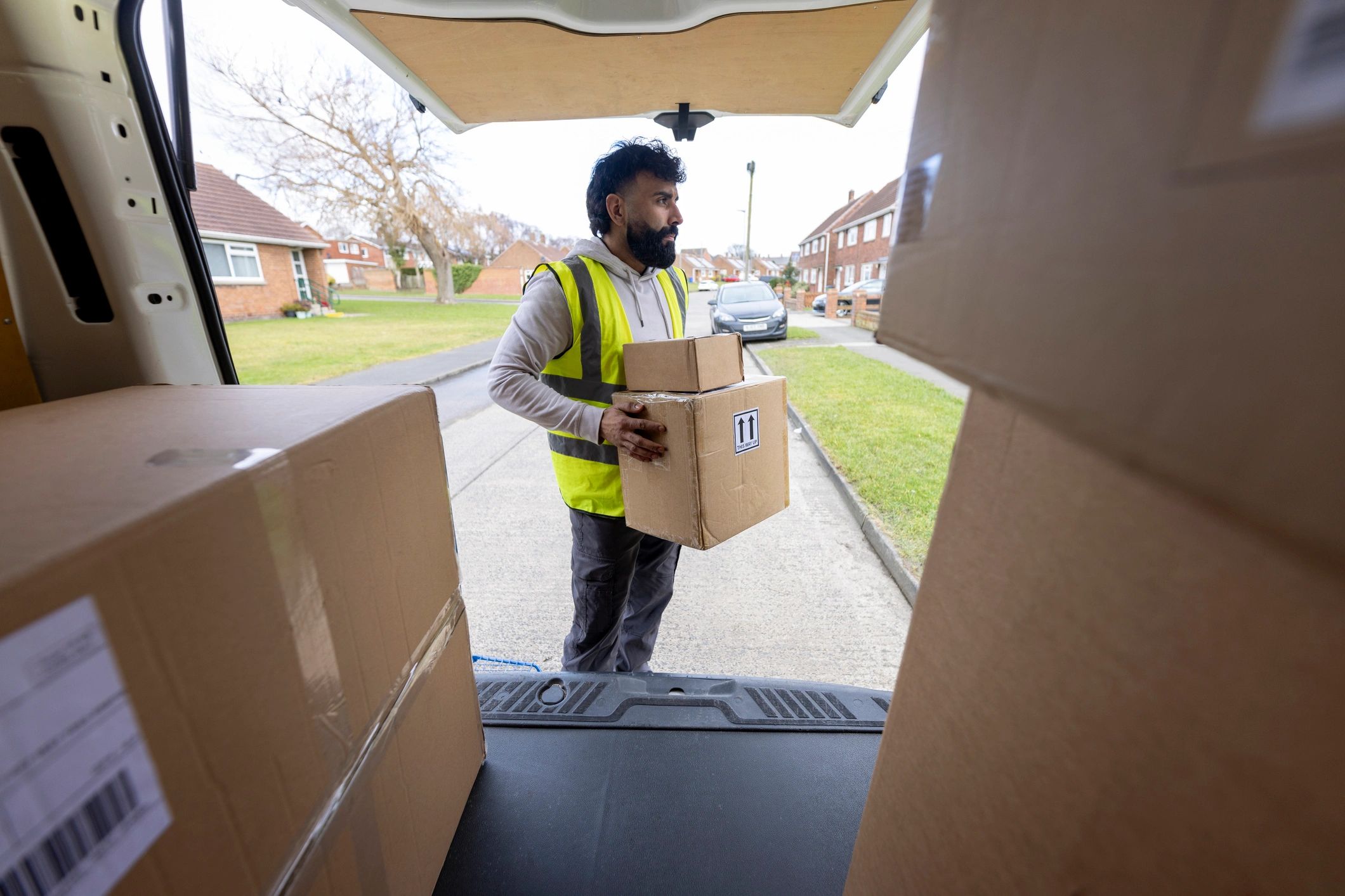 Delivery driver carrying a package from a van